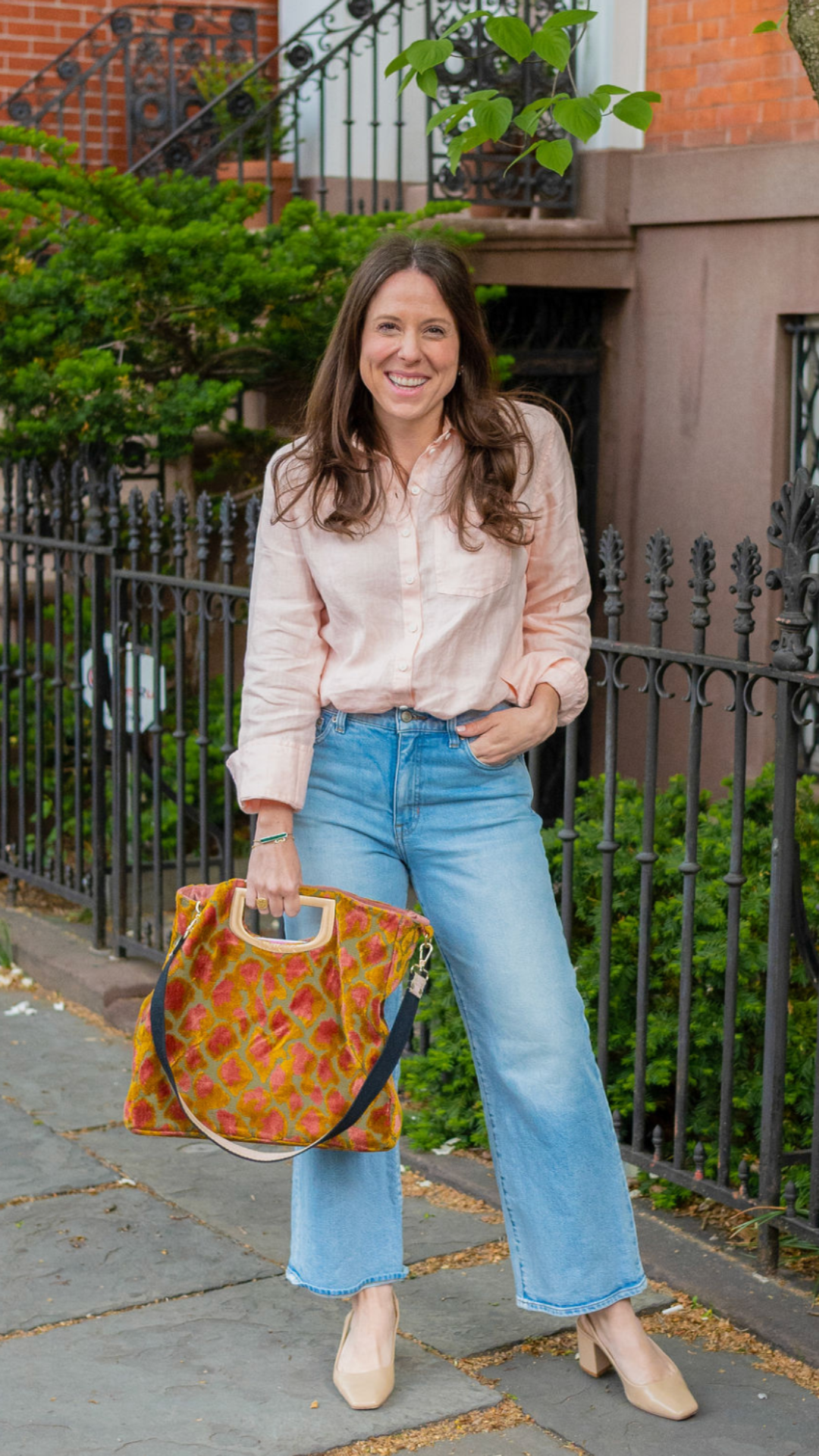 Elizabeth with a colorful tote bag on a brownstone block